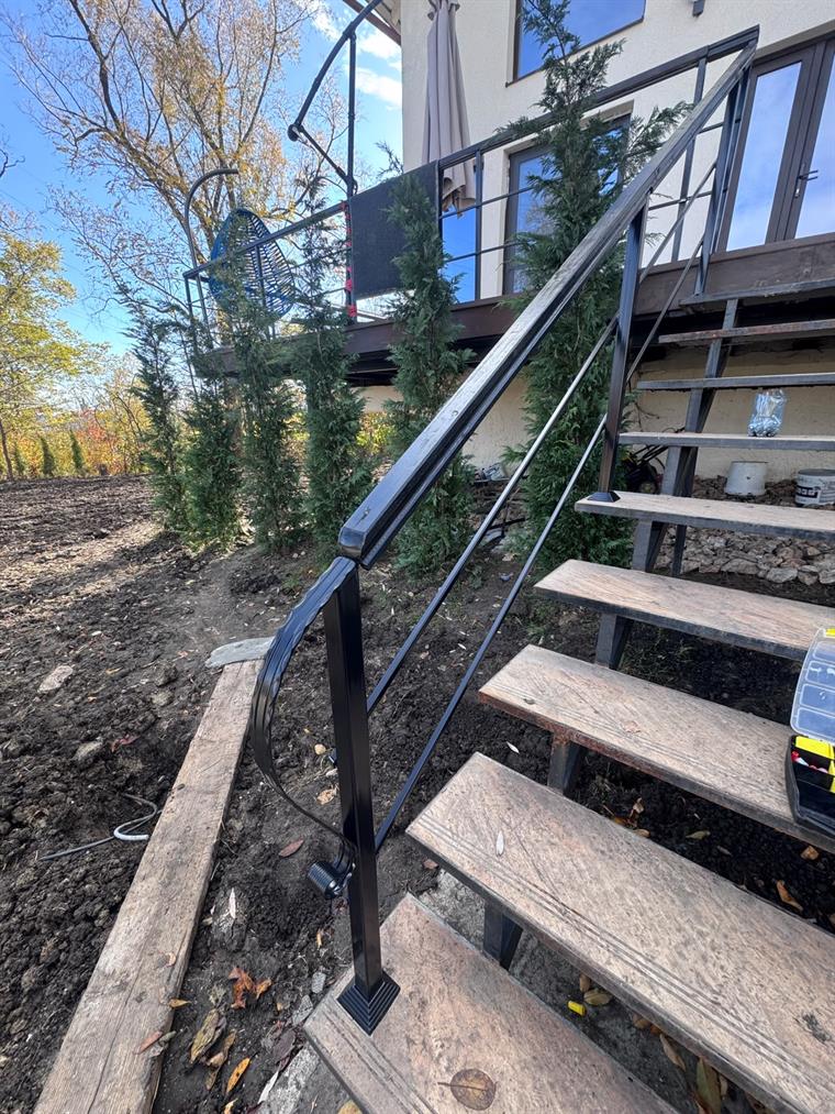 Balustradă metalică neagră pe scară exterioară cu trepte din lemn