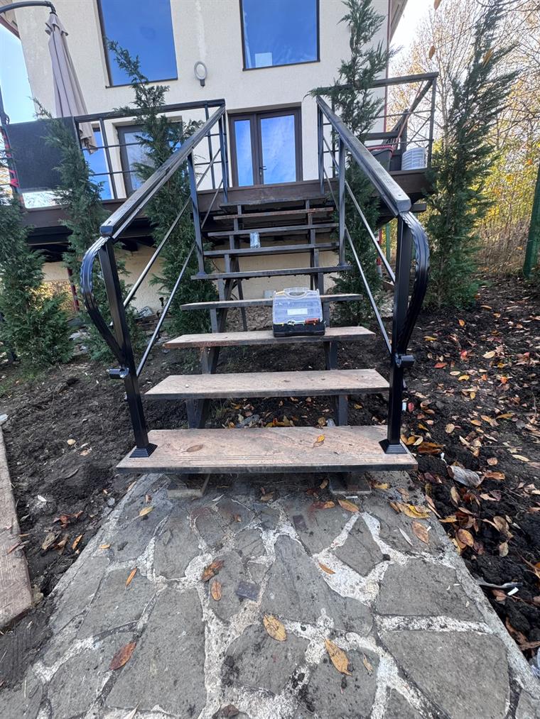 Scară exterioară cu balustradă neagră și terasă metalică