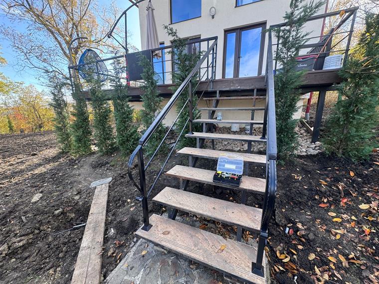 Scară exterioară cu balustradă neagră și balcon metalic