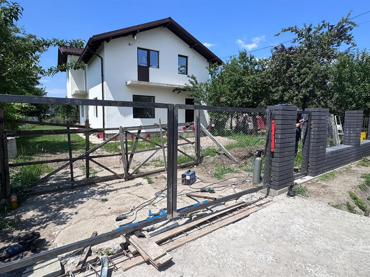 Montaj gard metalic antracit în curtea unei case