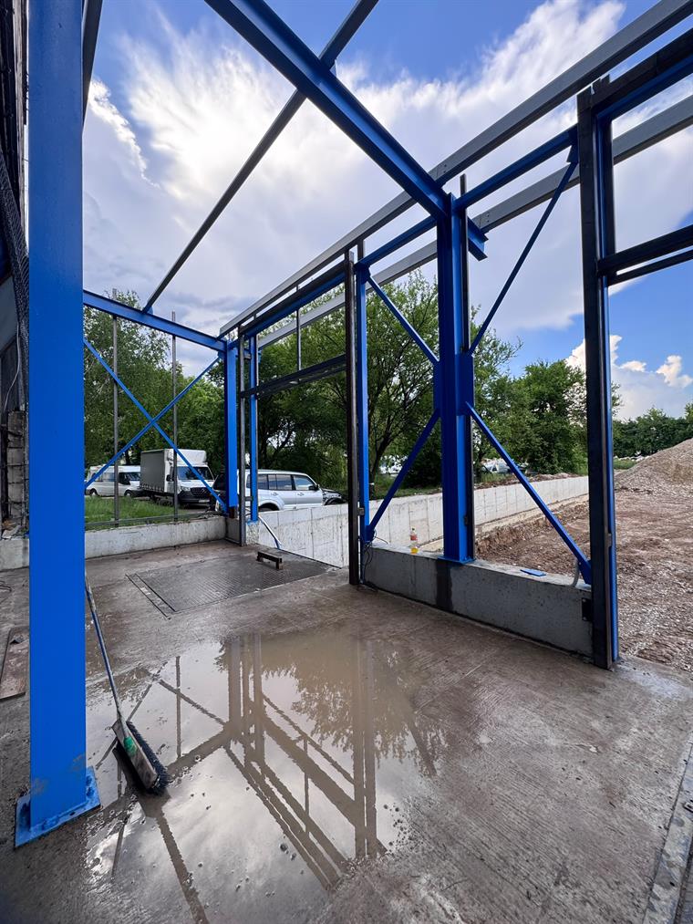 Structură metalică albastră cu contravântuiri pentru hală în construcție